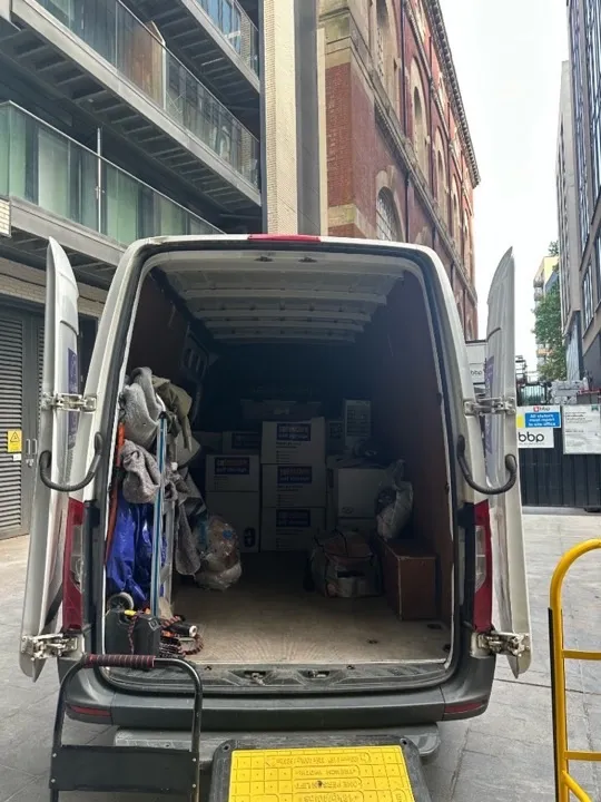 Business moves — van loaded with storage boxes Business move van loaded with Safestore boxes, moving blankets, and equipment parked between city office buildings