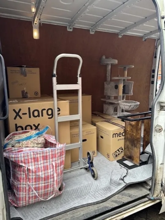 Fully loaded removals van Fully loaded removals van with labelled boxes, furniture, and stair-climbing hand truck for a household move