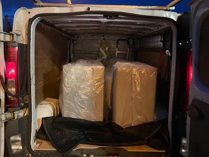Furniture collection — wrapped sofas in van Two large sofas wrapped in protective plastic on moving blankets inside a delivery van for a furniture collection service in Birmingham and the Midlands