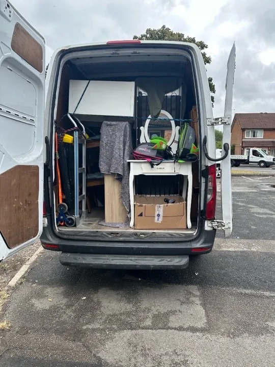House removals — secured furniture van load House removals van loaded with vanity, cabinets, and a hand truck secured with ratchet straps and bungee cords for a UK home move