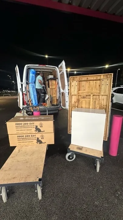 Long-distance moves — furniture on dollies Long-distance move loading at night with moving boxes on dollies and furniture ready to load into a secured removals van
