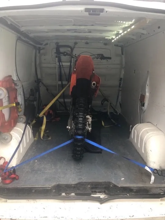 Motorcycle transport removals van Motorbike secured with tie-down straps for specialist motorcycle transport in a UK removals van