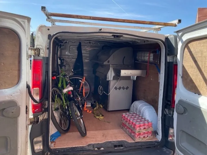 BBQ and bikes collection van White delivery van loaded with bicycles and a stainless steel gas grill for household item collection and delivery