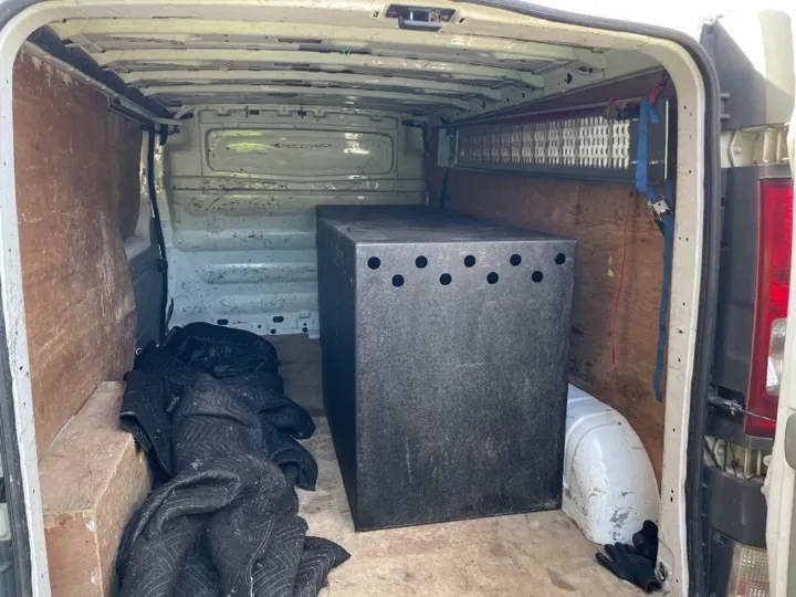 Small moves — protected crate in van Specialist crate secured inside a removals van with moving blankets and tie-down straps for a careful small-move delivery