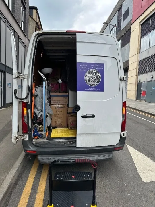 Student move van loaded with cardboard boxes, a floor lamp, and moving blankets ready for a UK university relocation