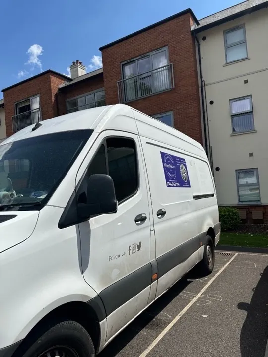 Removals van parked outside a modern residential building for a student house or flat move in Bristol, Cardiff, or Bath